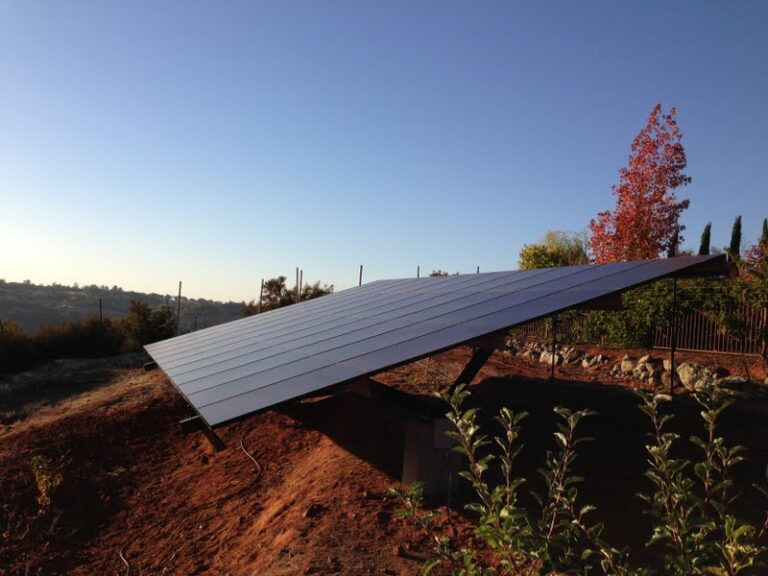 Solar Power System on a hillside against trees with leaves changing colors